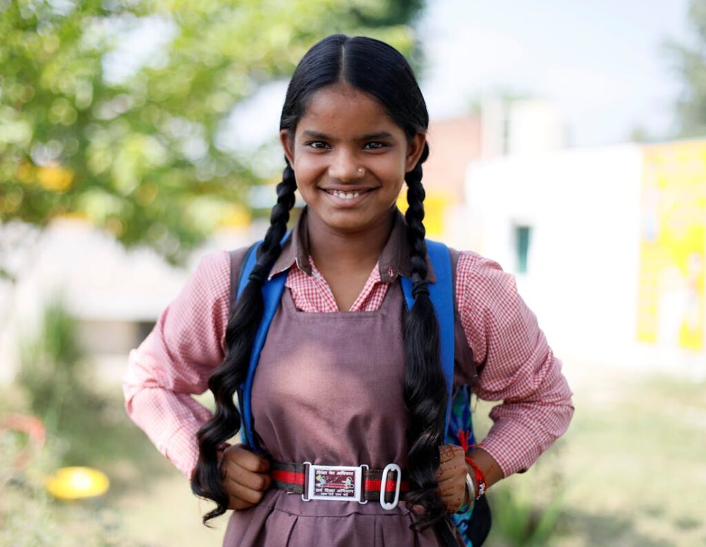 Cheerful Indian schoolgirl in uniform smiling outdoors in Lucknow, India.