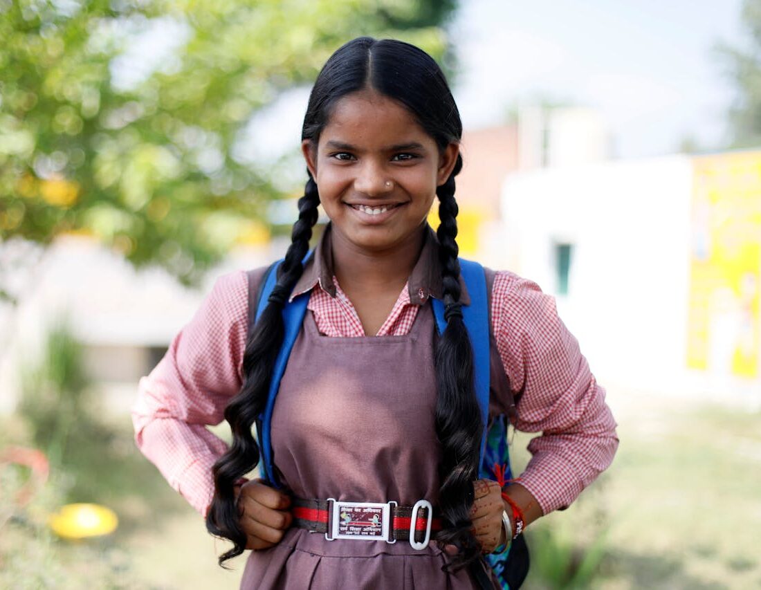 Cheerful Indian schoolgirl in uniform smiling outdoors in Lucknow, India.